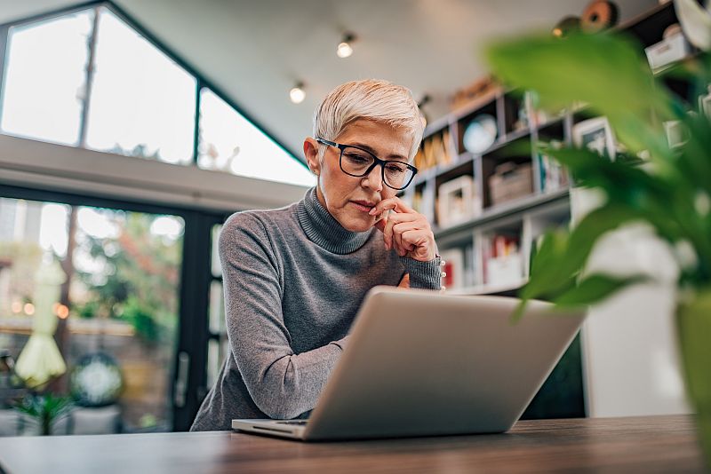 Portrait of a serious senior woman looking at laptop.